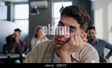 Nahaufnahme deprimiert besorgt jungen kaukasischen Kerl Student allein am Schreibtisch sitzen unter Mobbing Misshandlung durch Klassenkameraden Schüler Teenager leiden Stockfoto