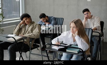 Junge Studenten Mitarbeiter Mitarbeiter unmotivierte Mitarbeiter sitzen im Klassenzimmer hören langweilige Vorlesung langwierige Trainer Lehrer bei Unternehmensseminar gelangweilt Stockfoto