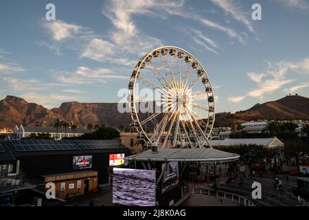 Kapstadt, Südafrika. 16.. Mai 2022. Am 16. Mai 2022 wird bei Sonnenuntergang an der V&A Waterfront, einer beliebten Touristenattraktion am Strand, in Kapstadt, Südafrika, ein Himmelsrad gesehen. Quelle: Lyu Tianran/Xinhua/Alamy Live News Stockfoto