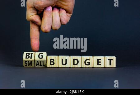 Großes oder kleines Budgetsymbol. Geschäftsmann dreht Holzwürfel und ändert Wörter kleines Budget zu großes Budget. Schöne graue Tabelle grauen Hintergrund, Kopie sp Stockfoto