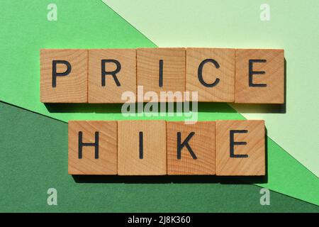 Preiserhöhung, Wörter in Holzbuchstaben isoliert auf grünem Hintergrund Stockfoto