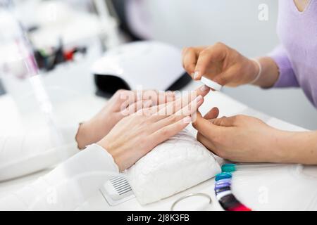 Frau Hände, mit denen die Maniküre Master Feilen Nägel Stockfoto