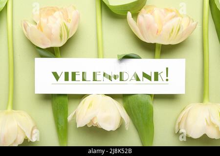 Karte mit Text VIELEN DANK und Blumen auf farbigem Hintergrund Stockfoto