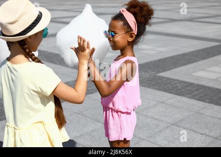 Nette kleine Mädchen mit Zuckerwatte im Freien Stockfoto