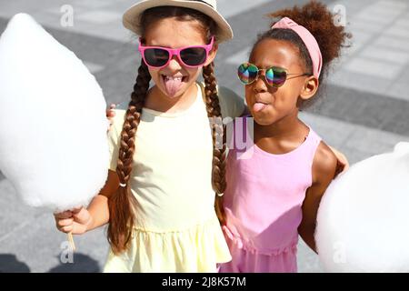 Nette kleine Mädchen mit Zuckerwatte im Freien Stockfoto