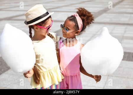 Nette kleine Mädchen mit Zuckerwatte im Freien Stockfoto