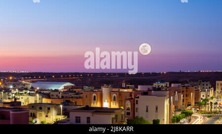 Vollmond über einem purpurnen Himmel in der marokkanischen Stadt Laayoune Stockfoto