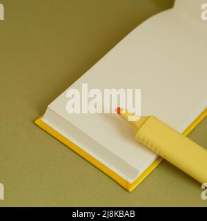 Leeres Notizbuch und gelbes Textmarker auf dem Schreibtisch öffnen Stockfoto