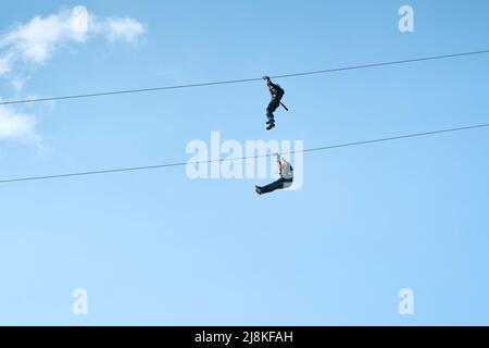 Zwei abenteuerlustige tapfere Männer auf einer Zipline in Magdeburg in Deutschland Stockfoto