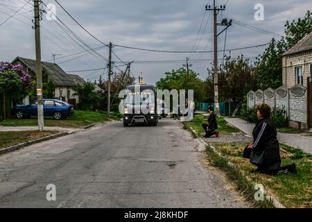 Balabyne, Ukraine. 13.. Mai 2022. Die Menschen knien vor dem Leichnam des toten Sergej Titow, Sergej Titow, Sergeant der Nationalgarde der Ukraine, der durch russische Schüsse in Orichiv in den Straßen von Balabyne, Region Saporischschja, getötet wurde. Russland marschierte am 24. Februar 2022 in die Ukraine ein und löste damit den größten militärischen Angriff in Europa seit dem Zweiten Weltkrieg aus (Bild: © Rick Mave/SOPA Images via ZUMA Press Wire) Stockfoto