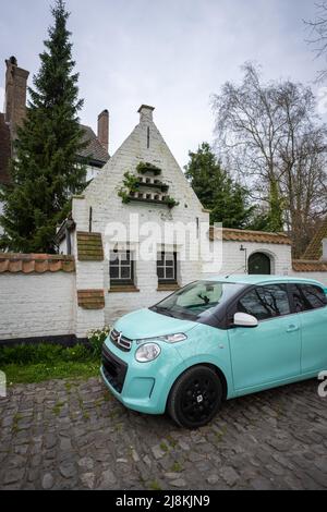 Teal Car auf einer gepflasterten Straße in Brügge, Belgien Stockfoto