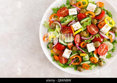 Griechischer Salat mit Feta-Käse, Tomaten, Gurken, Pfeffer, roten Zwiebeln und grünen Oliven. Draufsicht Stockfoto