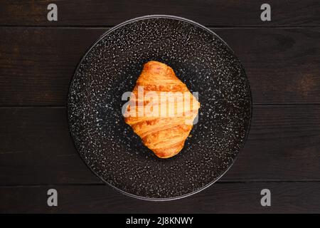 Blick von oben auf frisch gebackene große Croissants auf einem Teller Stockfoto