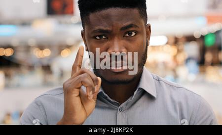 Nahaufnahme junger, ernsthafter, wütender afroamerikanischer Mann, der die Kamera missbilligend mit dem Finger schüttelt und so ein Verbot von Gesten der Meinungsverschiedenheit zeigt Stockfoto