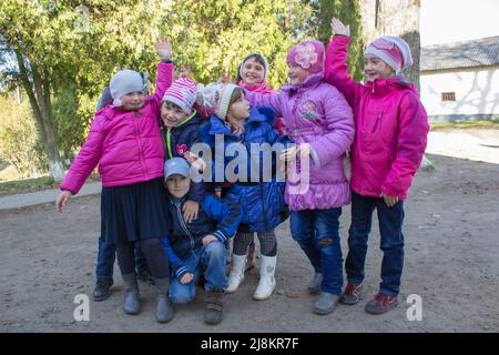 Positive spanische Kinder springen auf chinesisch springen elastisches Seil im Hof Stockfoto