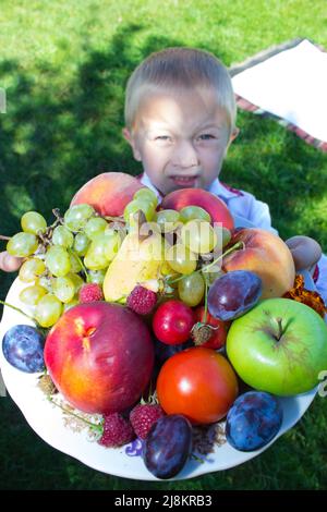 Junge hält Früchte Stockfoto