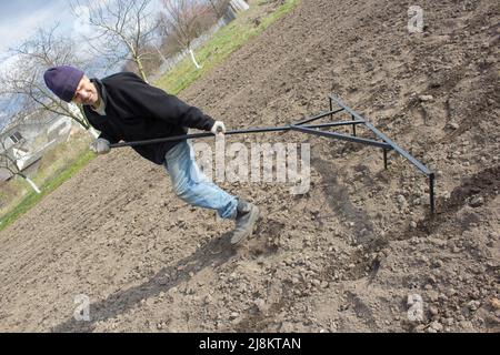 Einsamer Großvater arbeitet Frühling im Garten auf dem Boden Stockfoto
