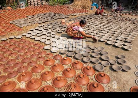 17. Mai 2022, Brahmanbaria, Chittagong, Bangladesch: Frauen arrangieren Tausende von Tontöpfen, bevor sie auf einen Markt in Brahmanbaria, Bangladesch, transportiert werden. Die Tontöpfe werden zum Trocknen unter dem brennenden Sonnenschein ausgelegt, bevor sie als Töpferei in Brennöfen geladen werden. Hier werden täglich rund 3.000 Tontöpfe hergestellt und jeder von ihnen wird für 2 Dollar (2 Dollar) verkauft. Die Töpferei, ein uralter Handel, wird nur von den Menschen der 'Pal'-Gemeinschaft (Potters Community) des Hinduismus betrieben. Seit Jahrhunderten leben sie von ihren Töpferkünsten. Auch heute noch sind ihre Töpfe aus Stockfoto