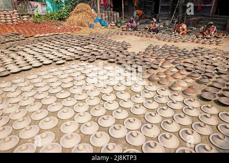 17. Mai 2022, Brahmanbaria, Chittagong, Bangladesch: Frauen stellen Tontöpfe her, um sie auf einem Markt in Brahmanbaria, Bangladesch, zu verkaufen. Die Tontöpfe werden zum Trocknen unter dem brennenden Sonnenschein ausgelegt, bevor sie als Töpferei in Brennöfen geladen werden. Hier werden täglich rund 3.000 Tontöpfe hergestellt und jeder von ihnen wird für 2 Dollar (2 Dollar) verkauft. Die Töpferei, ein uralter Handel, wird nur von den Menschen der 'Pal'-Gemeinschaft (Potters Community) des Hinduismus betrieben. Seit Jahrhunderten leben sie von ihren Töpferkünsten. Noch heute sind ihre Töpfe in ganz Bangladesch von enormer Nachfrage. The Wor Stockfoto