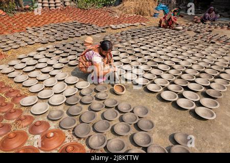 17. Mai 2022, Brahmanbaria, Chittagong, Bangladesch: Frauen arrangieren Tausende von Tontöpfen, bevor sie auf einen Markt in Brahmanbaria, Bangladesch, transportiert werden. Die Tontöpfe werden zum Trocknen unter dem brennenden Sonnenschein ausgelegt, bevor sie als Töpferei in Brennöfen geladen werden. Hier werden täglich rund 3.000 Tontöpfe hergestellt und jeder von ihnen wird für 2 Dollar (2 Dollar) verkauft. Die Töpferei, ein uralter Handel, wird nur von den Menschen der 'Pal'-Gemeinschaft (Potters Community) des Hinduismus betrieben. Seit Jahrhunderten leben sie von ihren Töpferkünsten. Auch heute noch sind ihre Töpfe aus Stockfoto