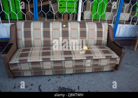 Gebrauchte Sofa zum Verkauf auf der Straße in der Nähe des Geschäfts Stockfoto