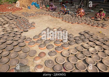 17. Mai 2022, Brahmanbaria, Chittagong, Bangladesch: Frauen stellen Tontöpfe her, um sie auf einem Markt in Brahmanbaria, Bangladesch, zu verkaufen. Die Tontöpfe werden zum Trocknen unter dem brennenden Sonnenschein ausgelegt, bevor sie als Töpferei in Brennöfen geladen werden. Hier werden täglich rund 3.000 Tontöpfe hergestellt und jeder von ihnen wird für 2 Dollar (2 Dollar) verkauft. Die Töpferei, ein uralter Handel, wird nur von den Menschen der 'Pal'-Gemeinschaft (Potters Community) des Hinduismus betrieben. Seit Jahrhunderten leben sie von ihren Töpferkünsten. Noch heute sind ihre Töpfe in ganz Bangladesch von enormer Nachfrage. The Wor Stockfoto