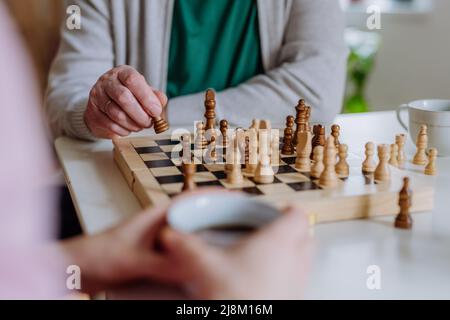 Nahaufnahme eines älteren Mannes, der mit seiner Tochter zu Hause Schach spielt. Stockfoto