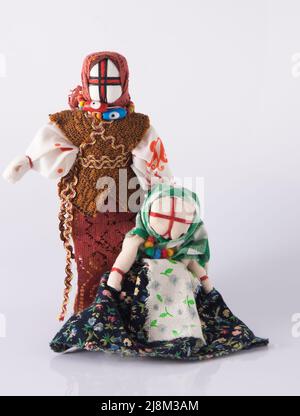 Lyalka motanka handgefertigt. Ukrainisches Puppenamulett, Schlammflecken und Fäden werden ohne Nadel hergestellt. Symbol der Ukraine. Motanka Puppen auf weißem Hintergrund. Altes Spielzeug. Stockfoto