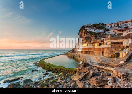 Malerisches Dorf Azenhas do Mar. Weiße Ferienhäuser am Rande einer Klippe mit einem Strand und Pool unten. Wahrzeichen in der Nähe von Lissabon, Portugal, Stockfoto