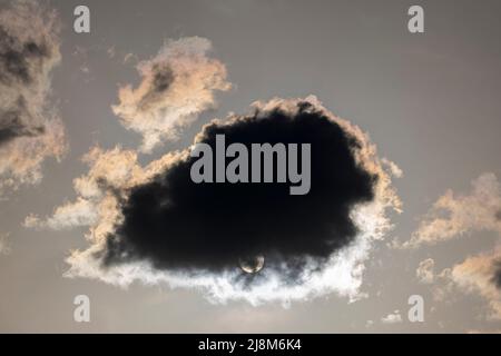 Das Bild der Wolken, die vor der Sonne vorbeigegangen sind, was eine dunkle Atmosphäre schafft. Stockfoto