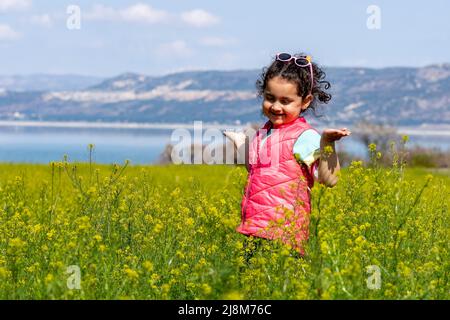 Selektive Fokusaufnahme eines kleinen Mädchens im Senffeld. Stockfoto