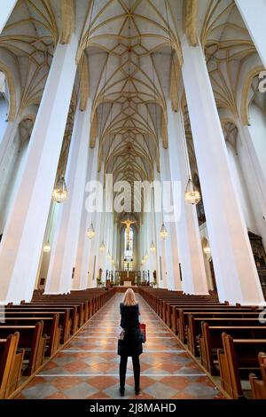 Deutschland Bayern München. Frauenkirche. Eine blonde, stehende Frau bewundert das Innere des Doms und verbringt Zeit in Stille und Kontemplation Stockfoto