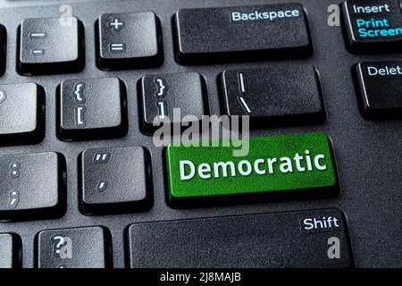 Demokratische grüne Taste auf einer schwarzen Desktop-Tastatur. Konzept der Online-Abstimmung für demokratische Partei, Wahlen in den Vereinigten Staaten und Politik. PC-Computer-Runde Stockfoto