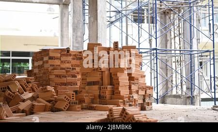 Haufen neuer Ziegelsteine auf der Baustelle. Konzept der Reparatur und Baustoffe Stockfoto