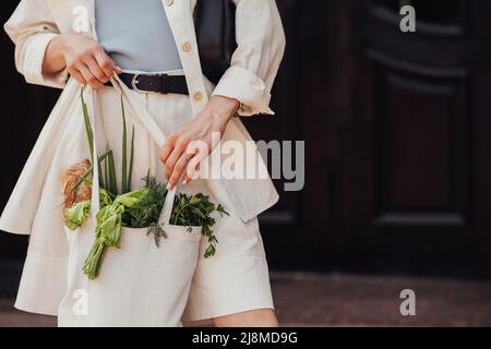 Nicht erkennbare stilvolle Frau hält Shopping Eco-Tasche mit Lebensmittel im Freien, Copy Space Stockfoto