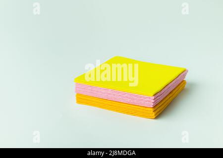 Weiche bunte Reinigungservietten auf grauem Hintergrund gestapelt Stockfoto