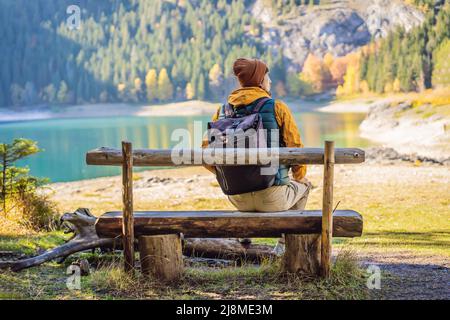 Mann Tourist im Hintergrund der Panoramablick am Morgen des Black Lake Crno Jezero. Ruhige Sommerszene im Durmitor Nacionalni Park, Zabljak Lage Stockfoto