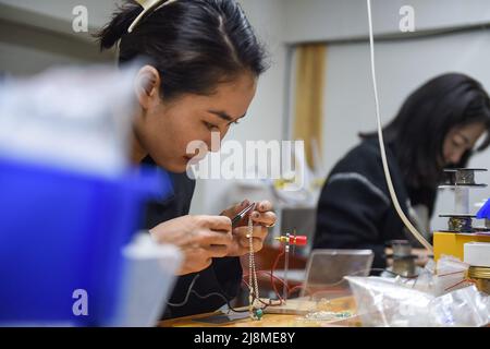 (220517) -- XILINGOL, 17. Mai 2022 (Xinhua) -- Tergel (L) und Zhang Aoyu stellen in ihrer Werkstatt in Xilinhot der Xilingol-Liga, der Autonomen Region Innere Mongolei im Norden Chinas, silberne Zubehörprodukte her, 16. Mai 2022. Tergel, ein Mädchen der mongolischen Volksgruppe, und Zhang Aoyu, alle geboren im Jahr 1990s, waren mit ihrem Silberzubehör beschäftigt, das Geschäfte mit mongolischen Merkmalen in Xilinhot der Xilingol Liga machte. Sie kannten sich im Jahr 2014 als Studenten an der Universität der Inneren Mongolei, und ihre gemeinsamen Interessen in der traditionellen ethnischen Kunst machten die beiden Mädchen zu einem Paar Stockfoto