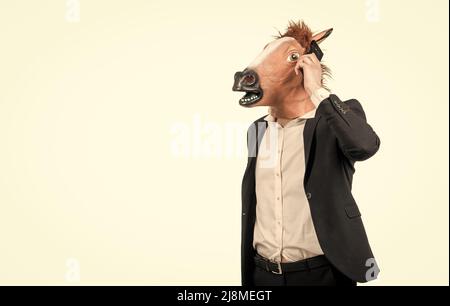 Professionelle fleißige Mann in Pferdekopfmaske sprechen auf Handy, Kommunikation Stockfoto