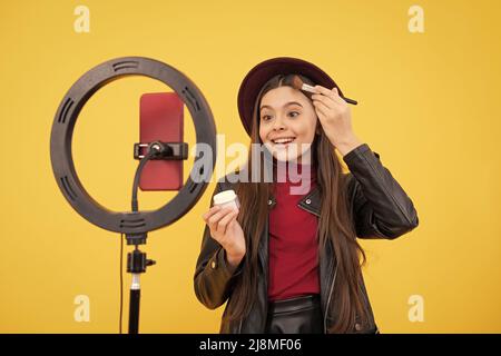 Happy teen Mädchen blogger verwenden Selfie LED Lampe und Smartphone auf Stativ, Blog. Stockfoto