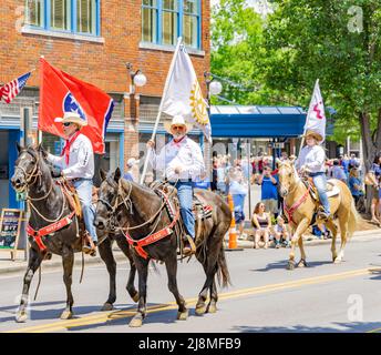 Männer auf Pferden mit Fahnen bei der Franklin Rodeo Parade Stockfoto