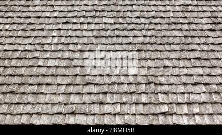 Verwitterte Holzschindeln auf einem Dach. Hölzerne Dachziegel des alten Hauses Stockfoto