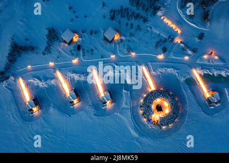 Luftaufnahme des beleuchteten Arctic Bath Hotel aus Holz in der verschneiten Landschaft in der Dämmerung, Harads, Lappland, Schweden Stockfoto