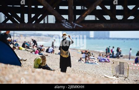 Brighton UK 17. May 2022 - Besucher genießen die heiße Sonne am Brighton Beach, da heute die heißesten des Jahres sein werden, da die Temperaturen in einigen Teilen Großbritanniens voraussichtlich 26 Grad erreichen werden: Credit Simon Dack / Alamy Live News Stockfoto