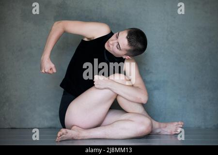 Nicht binär, sie/sie in Squat-Position Stockfoto