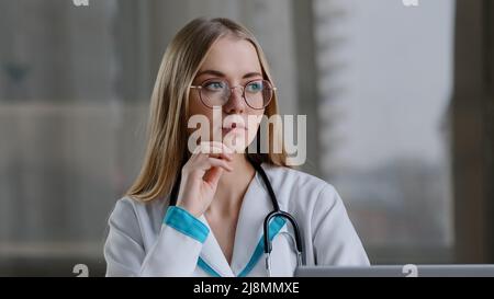 Fokussierte kaukasische weibliche nachdenkliche Krankenschwester intelligente Frau Praktiker Arzt denken an Problemdiagnose Termin Lösung trifft Entscheidung kommt mit Stockfoto