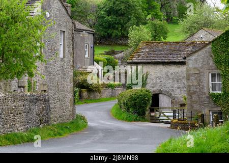 Ruhiges Conistone Dorf (attraktive Steingebäude, grüne Felder auf steilen Talhängen, kurvenreiche Straße) - Wharfedale, Yorkshire Dales, England, Großbritannien. Stockfoto