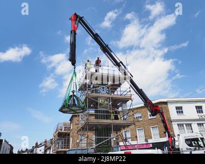 Sheerness, Kent, Großbritannien. 17.. Mai 2022. Der legendäre Uhrenturm Sheerness Town Center, der 1902 zur Erinnerung an die Krönung von König Edward VII. Errichtet wurde, wurde vom Uhrmacher Smith von Derby umfassend renoviert und in einem neuen Grün/Gold-Farbkonzept gestrichen. Heute um 1pm Uhr gab es eine „Richtfest“-Zeremonie, als die Glocke und das Spitzenstück der Uhr vorsichtig wieder in Position gebracht wurden. Kredit: James Bell/Alamy Live Nachrichten Stockfoto