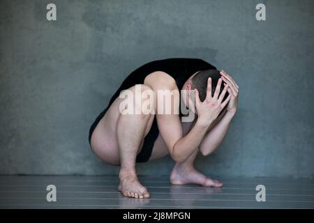 Nicht binär, sie/sie in Squat-Position Stockfoto