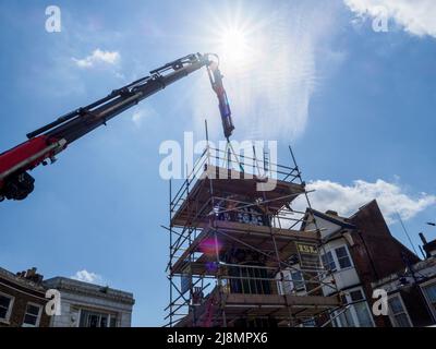 Sheerness, Kent, Großbritannien. 17.. Mai 2022. Der legendäre Uhrenturm Sheerness Town Center, der 1902 zur Erinnerung an die Krönung von König Edward VII. Errichtet wurde, wurde vom Uhrmacher Smith von Derby umfassend renoviert und in einem neuen Grün/Gold-Farbkonzept gestrichen. Heute um 1pm Uhr gab es eine „Richtfest“-Zeremonie, als die Glocke und das Spitzenstück der Uhr vorsichtig wieder in Position gebracht wurden. Kredit: James Bell/Alamy Live Nachrichten Stockfoto